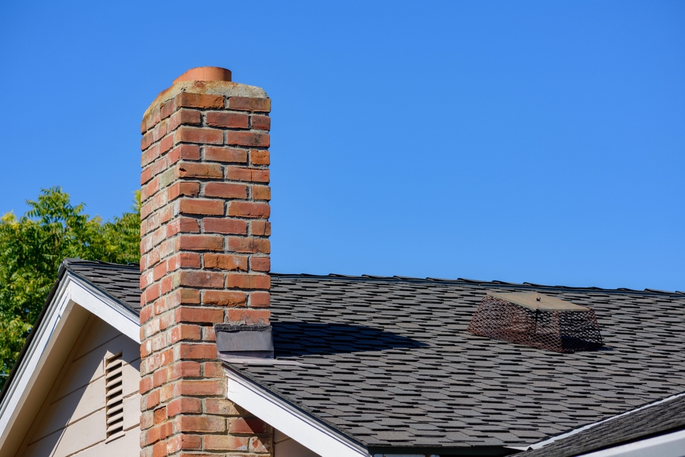 Brick chimney protruding from the roof of a house